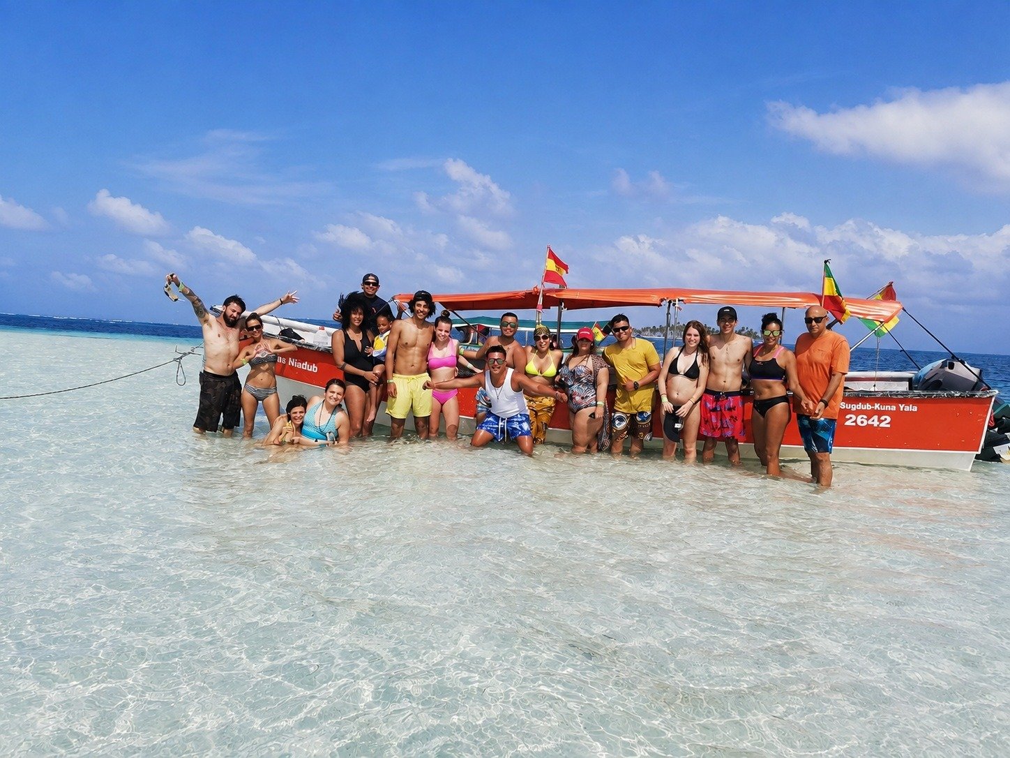 Grupo completo del tour junto a la lancha en aguas cristalinas